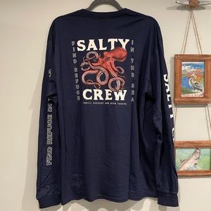 SALTY CREW LONG SLEEVE GRAPHIC TEE IN NAVY WITH LOGOS DOWN ARMS. SIZE LARGE
